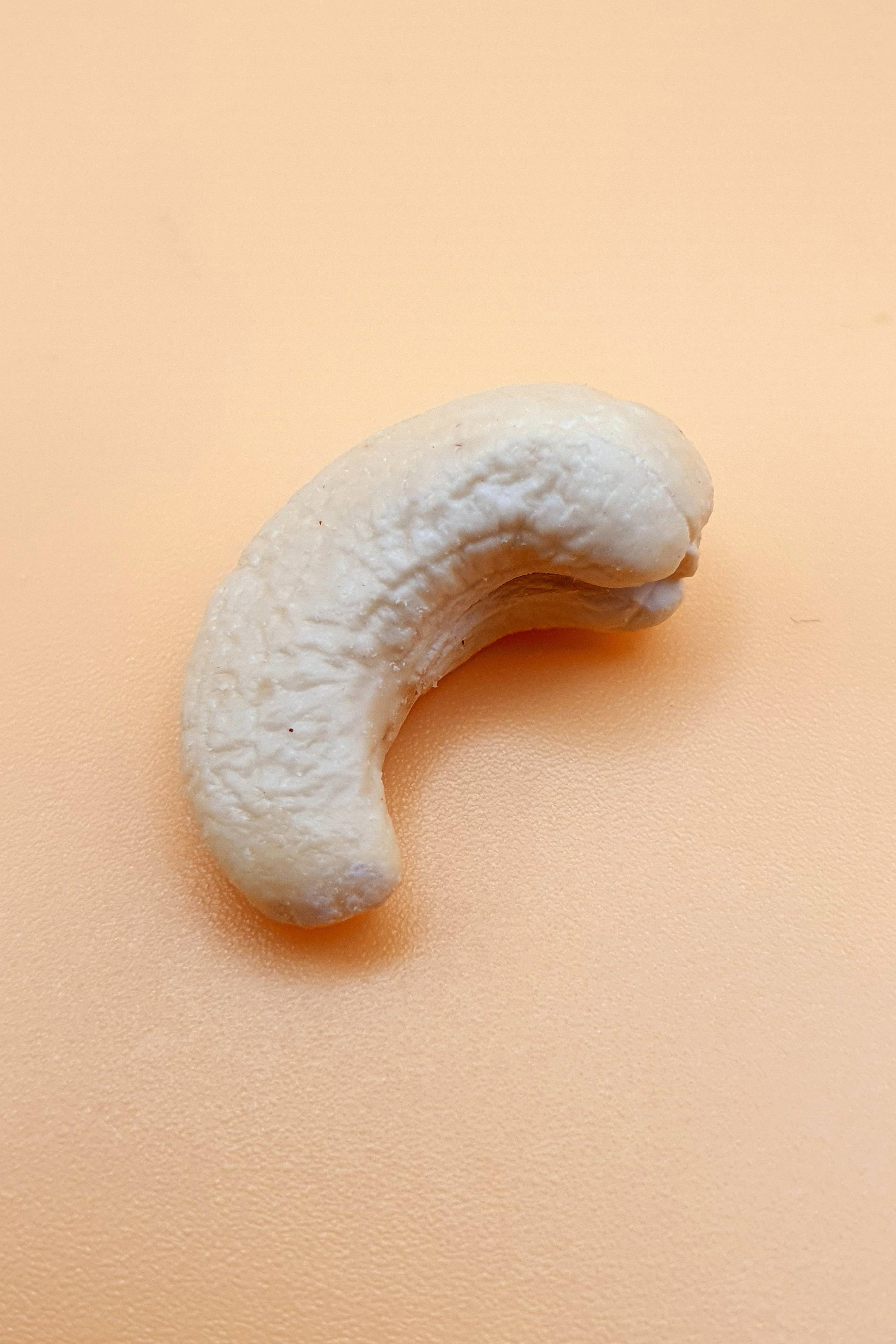 ein Cashewkern pur vor neutralem Hintergrund