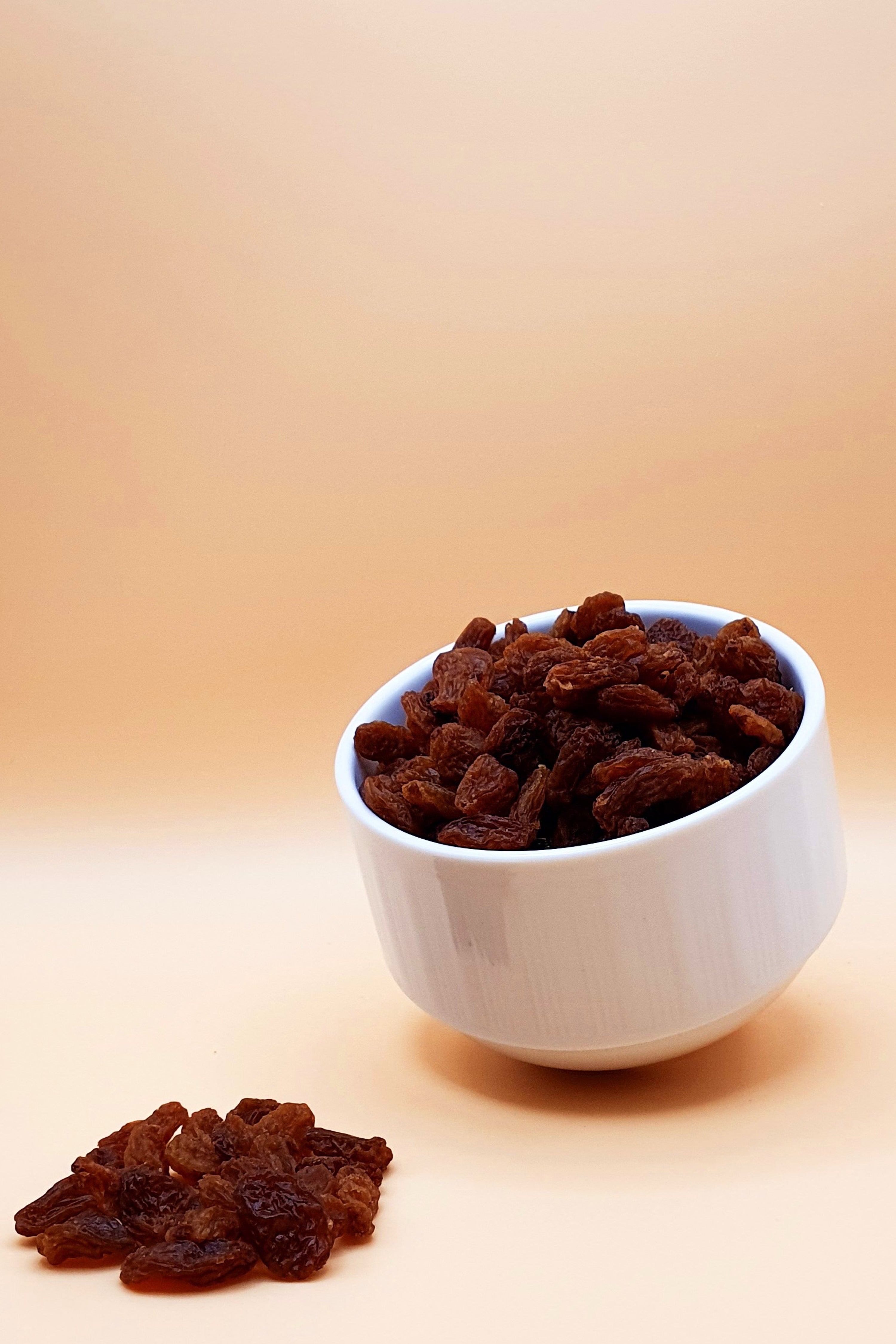 Sultanas und Rosinen 1000 g serviert in einer Schale vor neutralem Hintergrund