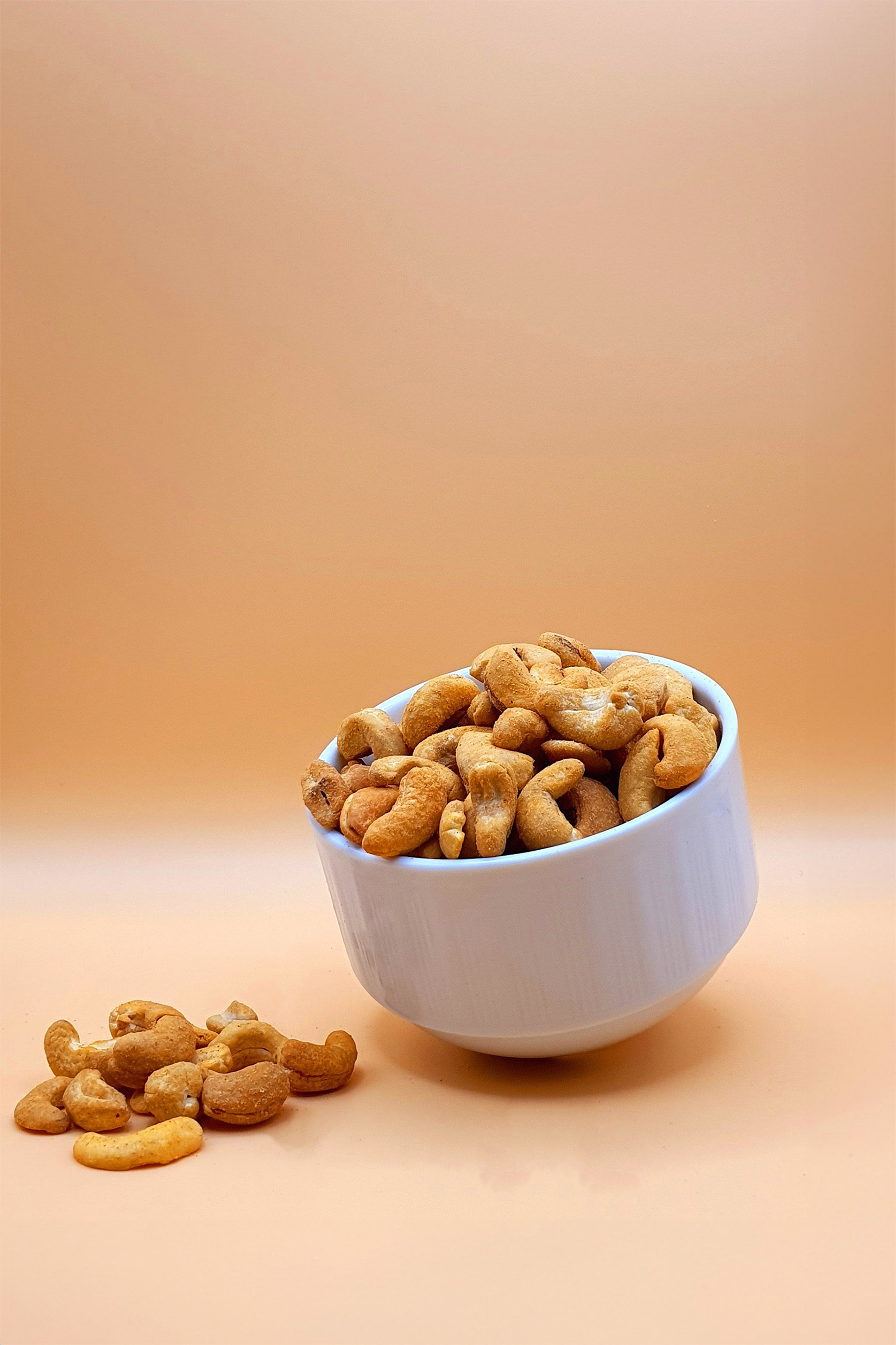 Cashewkerne scharf mit Chili 1000 g serviert in einer Schale vor neutralem Hintergrund