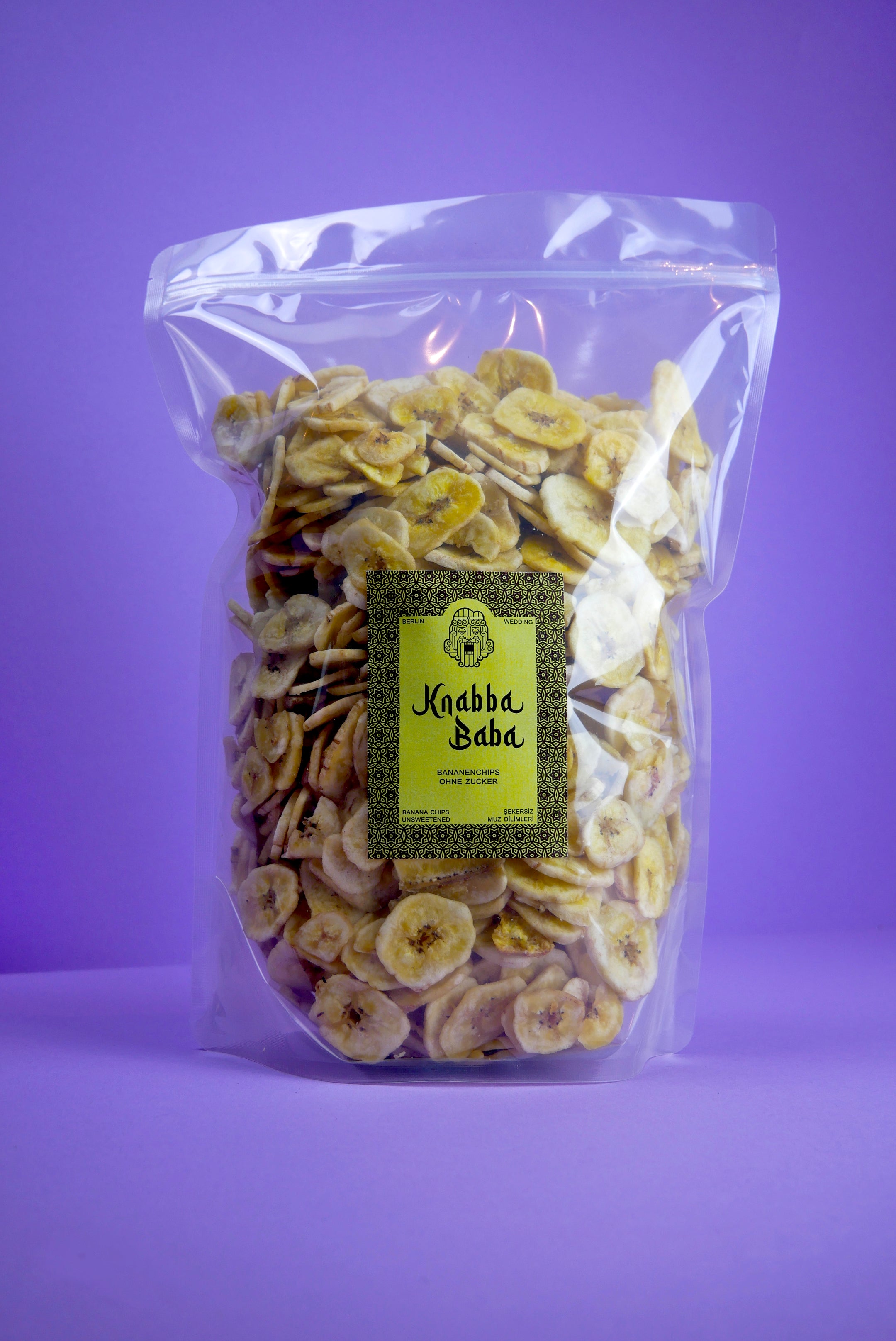 Knabba Baba naturbelassene Bananenchips 1 kg in wiederverschließbarer Verpackung vor lila Hintergrund