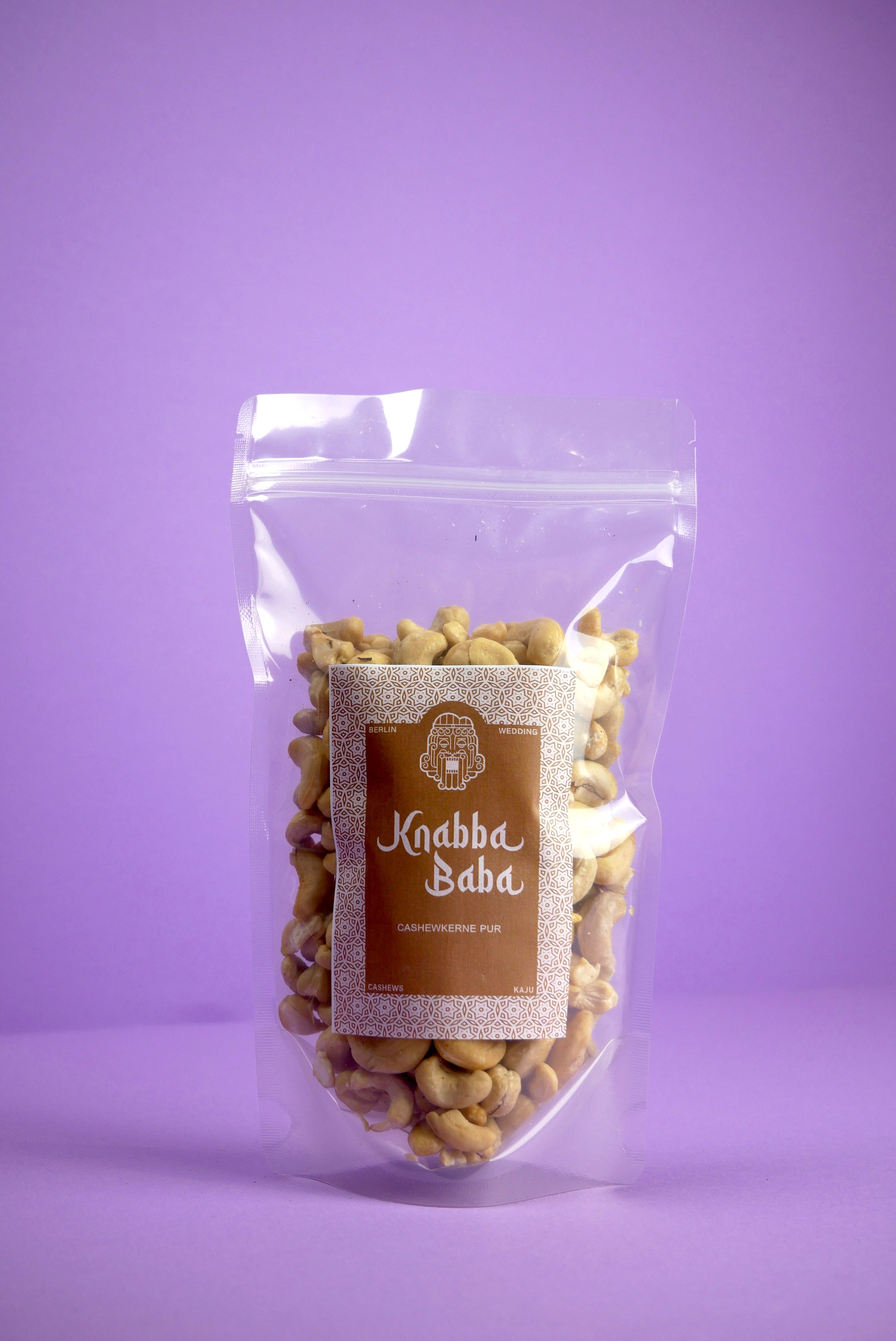 Knabba Baba Cashewkerne Premium 250g im wiederverschließbaren Beutel vor lila Hintergrund