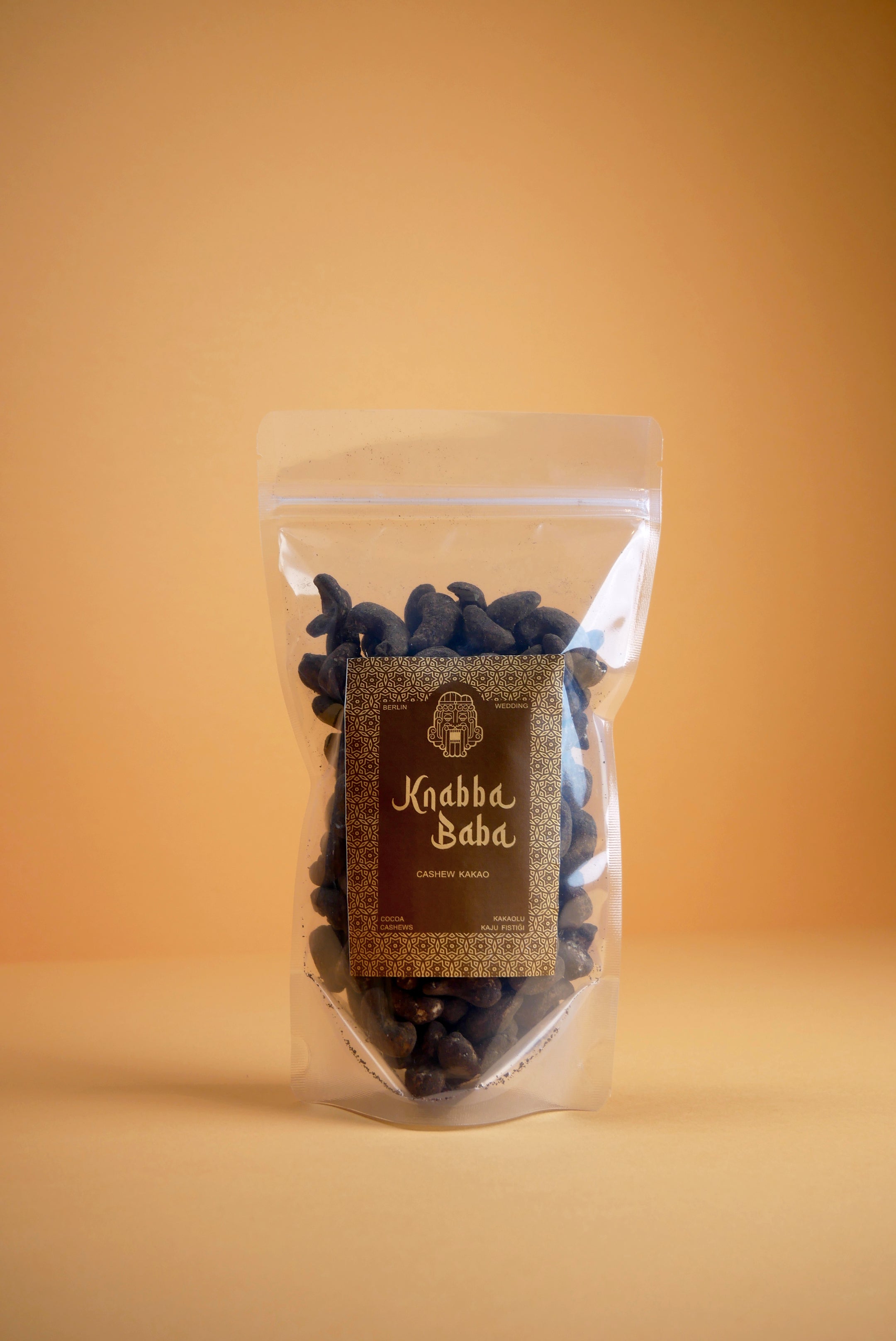 Knabba Baba Cashewkerne mit Kakao 250 g in wiederverschließbarer Verpackung vor beigem Hintergrund