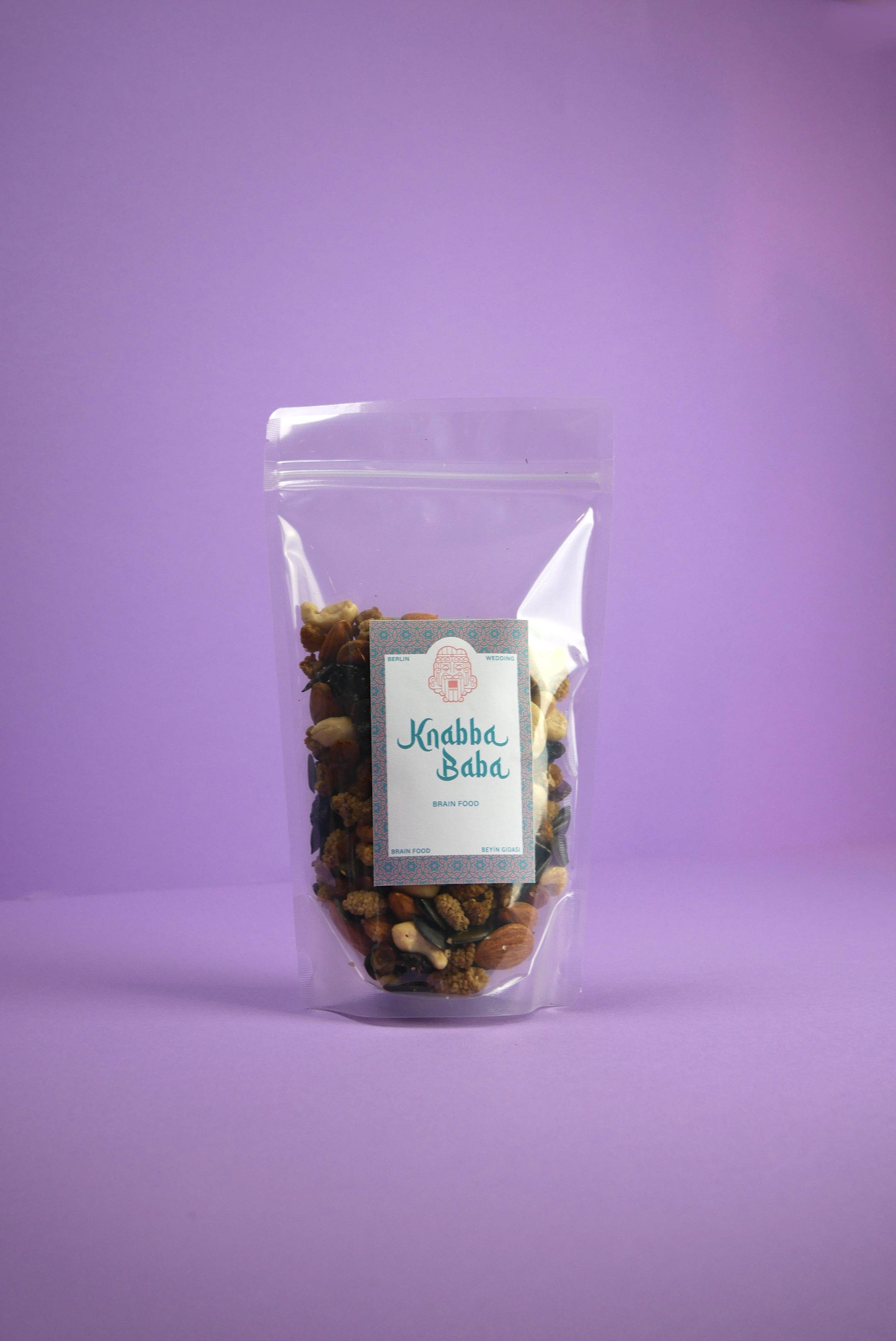 Knabba Baba Nussmischung Brain Food 250 g im wiederverschließbaren Beutel vor lilanem Hintergrund