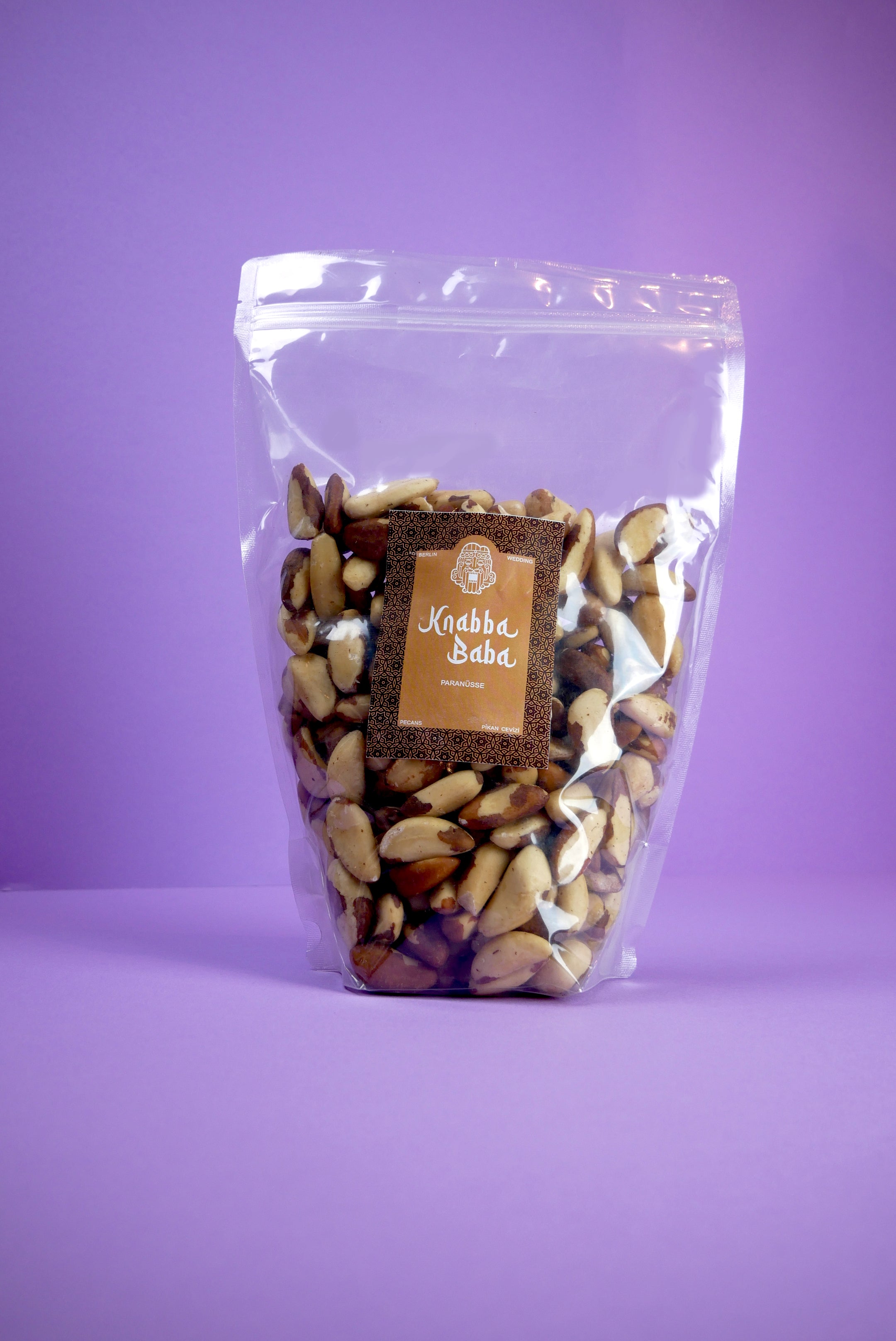 Knabba Baba Paranüsse 1 kg in transparente wiederverschließbare Verpackung vor lila Hintergrund