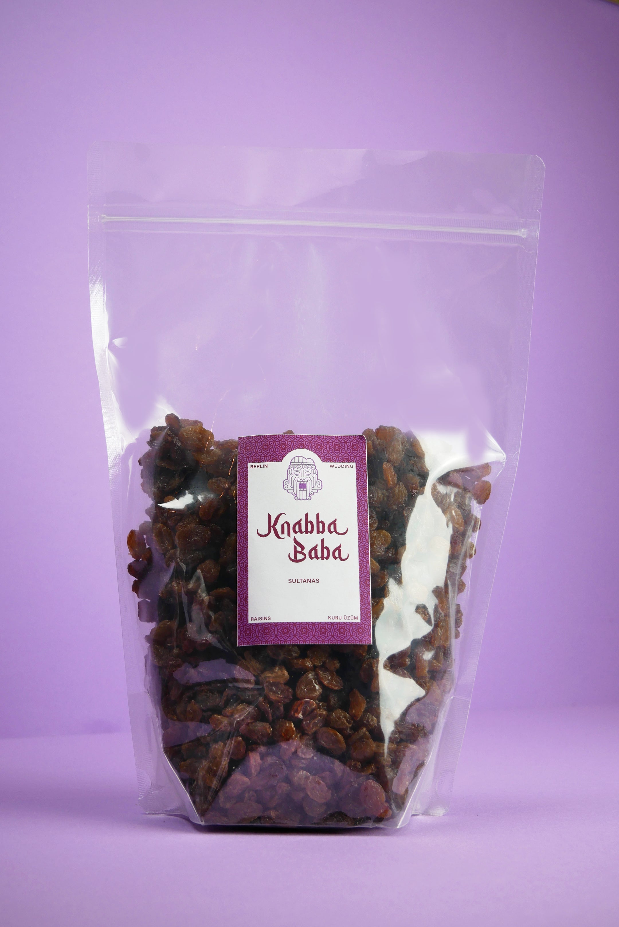 Knabba Baba Rosinen Sultanas 1 kg  in wiederverschließbarem transparentem Beutel vor lila Hintergrund