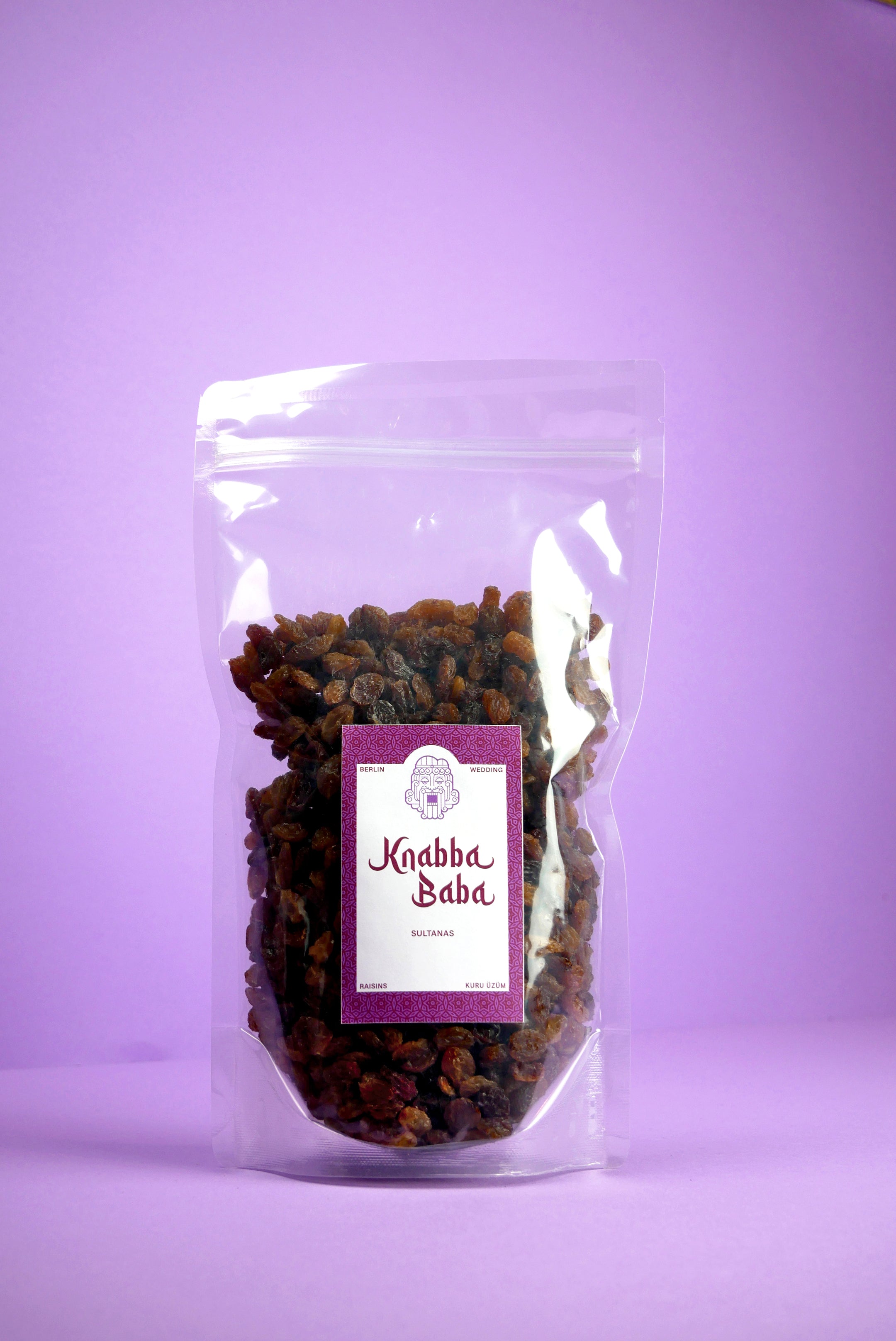 Knabba Baba Rosinen Sultanas 500 g im wiederverschließbaren Plastikbeutel vor lila Hintergrund
