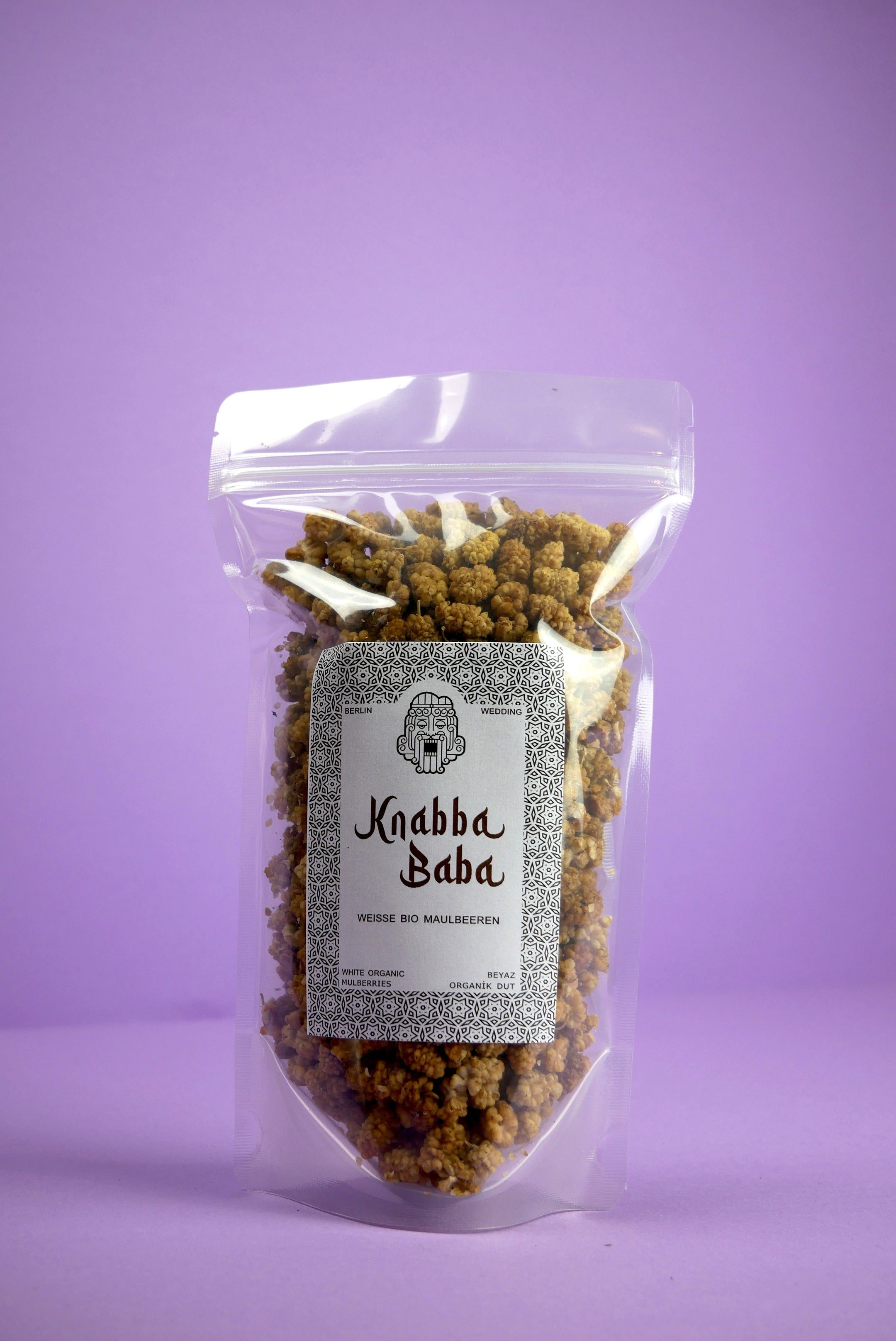 Knabba Baba - weiße Bio Maulbeeren 250 g in wiederverschließbarer Verpackung vor lila Hintergrund